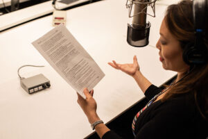 Femme qui lit un script avec un micro 